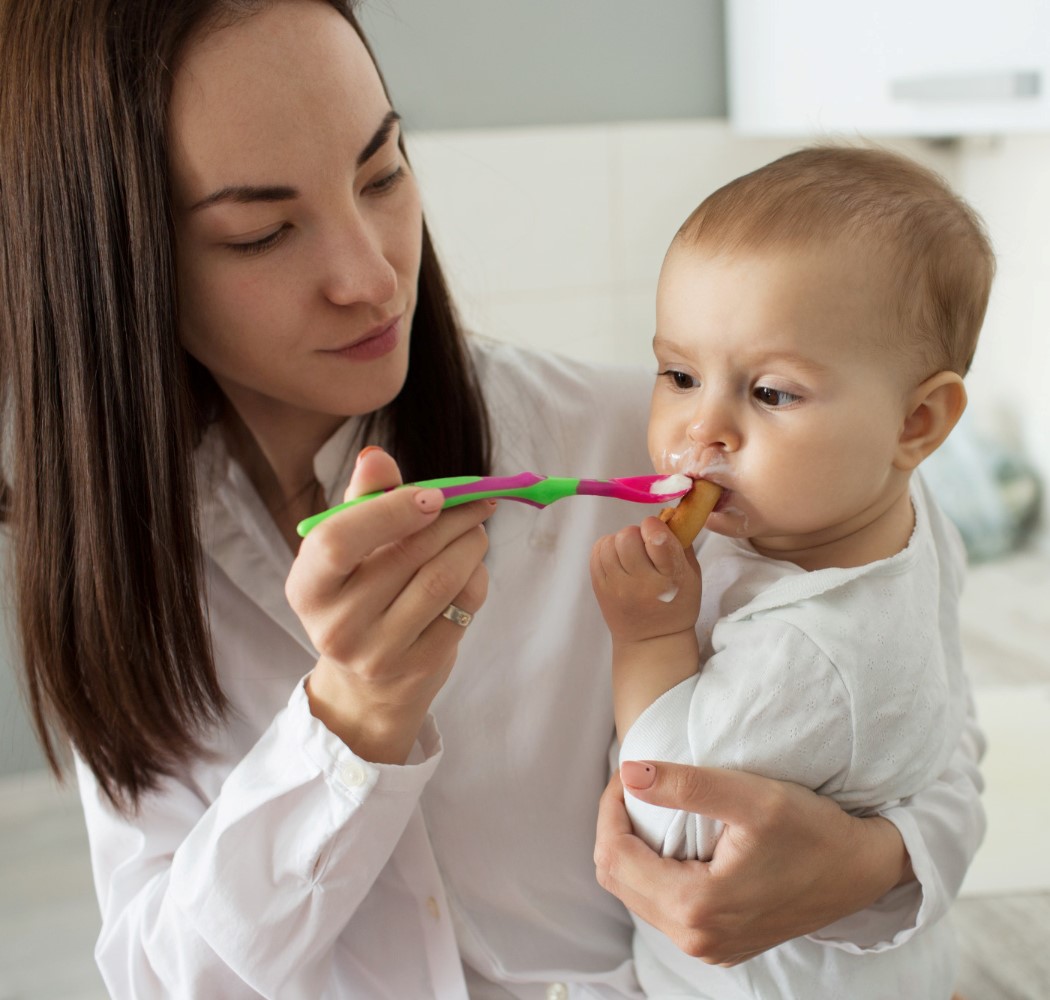 child eating while mom holding