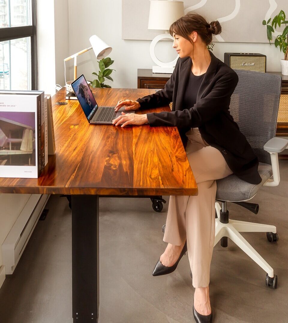 a woman sitting at a desk using a laptop computer